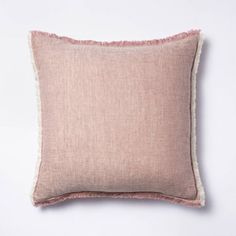 a pink and white pillow with fringe trims on it, against a white background