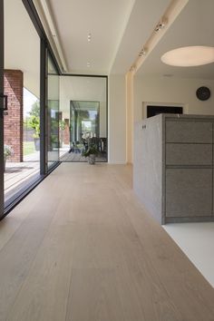 an empty room with wooden floors and sliding glass doors that lead to the outside patio