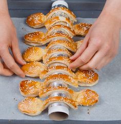 a person placing pretzels into a baking pan