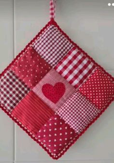 a red and white patchwork heart hanging on the wall