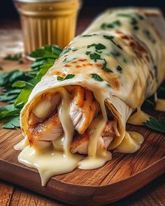 a wooden cutting board topped with meat and cheese covered in sauce