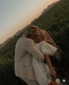 a man and woman are kissing in the grass