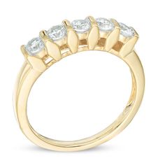 a yellow gold ring with five diamonds