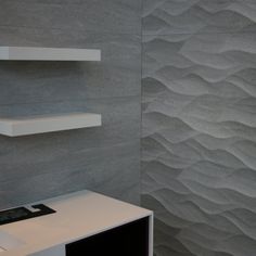 a bathroom with a sink and shelves on the wall in front of it's wavy design