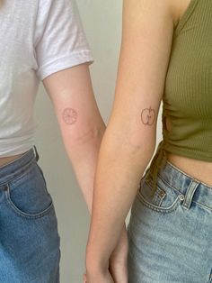 two women with matching tattoos on their arms