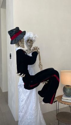 two skeletons dressed in costumes are standing next to each other and one is holding the back of another skeleton