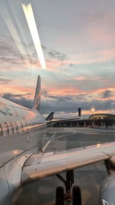 an airplane sitting on the tarmac at sunset