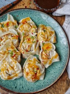 a blue plate topped with dumplings covered in sauce