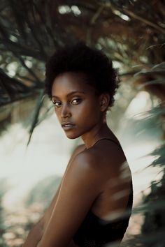 a woman in a black top is posing for the camera