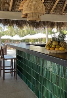 a bar with some fruit on it next to a chair and table in the background