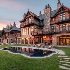 a large house with a pool in front of it and lots of windows on the side