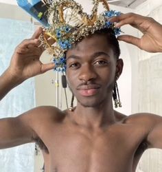 a shirtless man is holding his hair in front of his head with beads on it