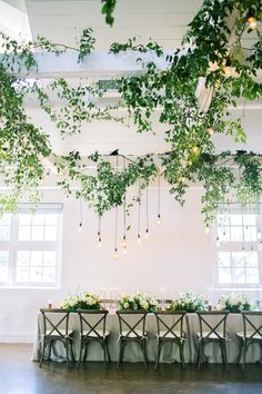 the table is set up with greenery and candles for an elegant dinner party or reception