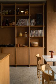 a room with shelves, chairs and tables in front of the counter top is filled with records