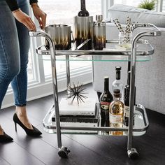 a woman standing next to a table with bottles on it