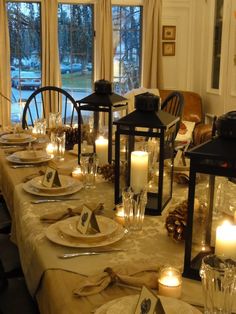 a long table with candles and plates on it