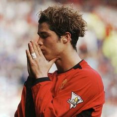 a soccer player is holding his hands together and praying in front of an audience at a stadium