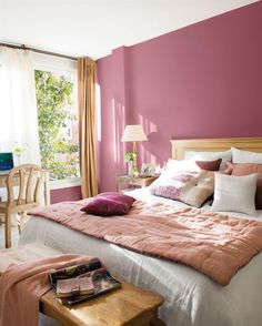 a bedroom with pink walls and white bedding