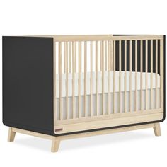 a baby crib that is made out of wood and has black paint on the sides