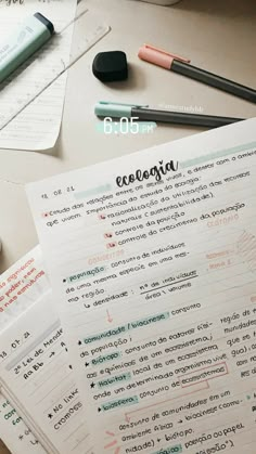 a table topped with lots of papers and pens