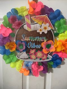 a wreath made out of paper flowers on a door with the words summer vibes painted on it