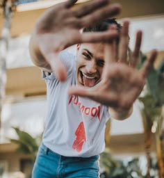 a man is smiling and holding his hands in the air