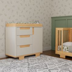 a baby crib next to a dresser in a room