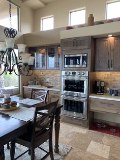 a kitchen with an oven, dining table and chandelier