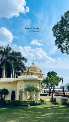 a white building surrounded by palm trees under a blue sky with the words look at the sky