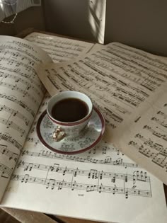 a cup of coffee sitting on top of music sheets