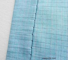 closeup of the side of a light blue suit with black stitching on it