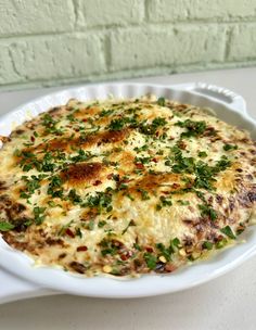 a white casserole dish filled with cheese and herbs