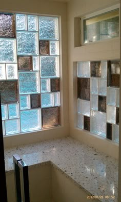 a bath tub sitting next to a window in a bathroom with glass blocks on the wall