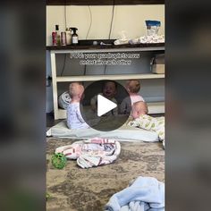 two baby babies are playing under a table