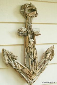 an anchor made out of driftwood on the side of a house