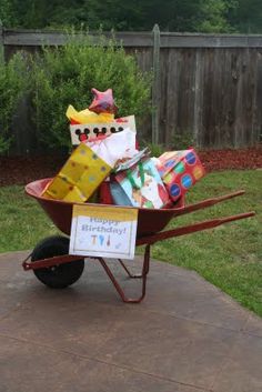 a wheelbarrow filled with lots of presents on top of a backyard patio area