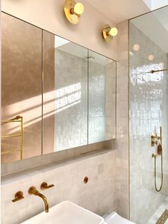 a bathroom with a sink, mirror and gold faucet lights on the wall