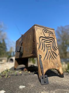 a wooden box with an eagle carved on it's side sitting on the ground