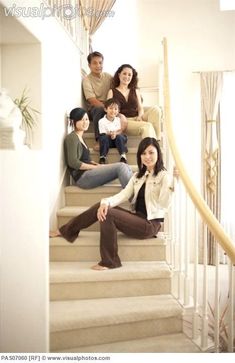 a group of people sitting on the stairs in front of a staircase with their children