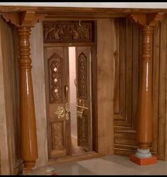 an open wooden door to a room with columns and pillars on the floor in front of it