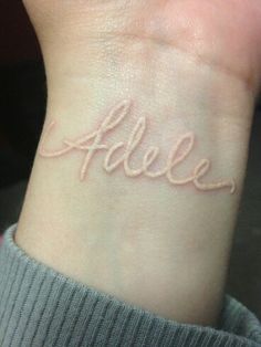 a small wrist tattoo with the word alice written in cursive writing on it