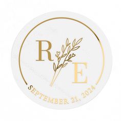 a round white and gold wedding sticker with the letter e on it's side