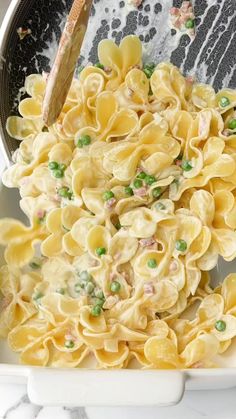 a bowl filled with pasta and peas on top of a table