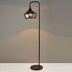 a lamp that is sitting on top of a white table next to a gray wall