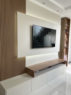 a flat screen tv mounted to the side of a white wall in a living room