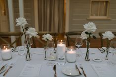 the table is set with white flowers and candles