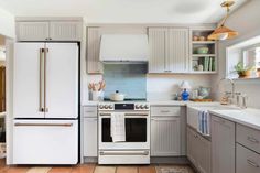 a kitchen with white cabinets and silver appliances