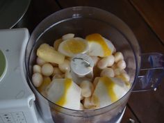 a food processor filled with fruit on top of a wooden table