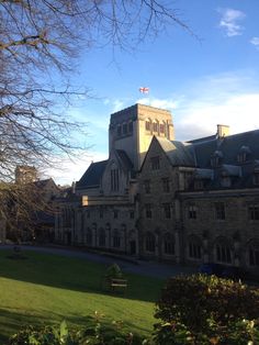 a large building with a clock tower on the top and green grass in front of it