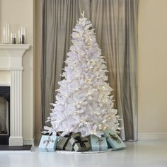 a white christmas tree with presents under it